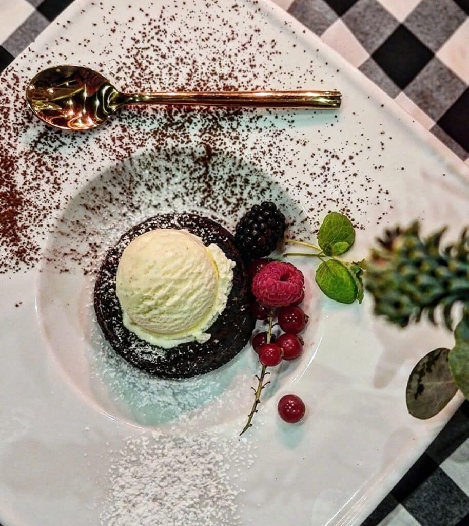 A chocolate dessert with ice cream, raspberries and blackberries