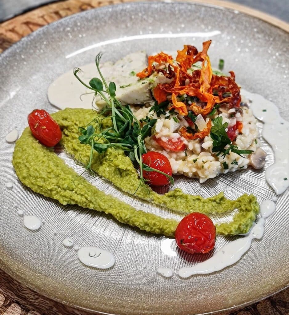 A plated dish with vegetables and green purée