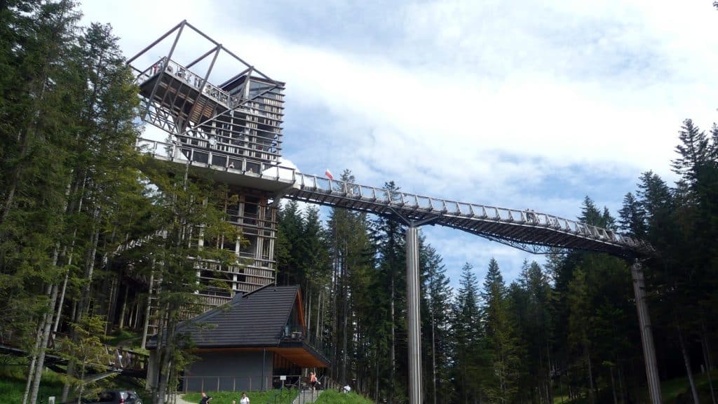 A wooden observation tower and elevated forest walkway at Brama w Gorce in Waksmund